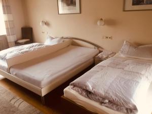 two beds in a bedroom with white sheets at Apartment am Rathaus in Rödermark
