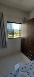 um quarto com uma janela e uma cama num quarto em Hostel aiuruoca em Aiuruoca