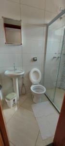 um banheiro com vaso sanitário, pia e chuveiro em Hostel aiuruoca em Aiuruoca