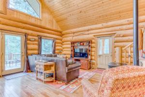 Cabaña de madera con sala de estar con sofá y TV en Edgewood, en Welches
