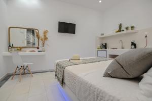biała sypialnia z łóżkiem i lustrem w obiekcie Jardin De Castillo , Naxos Town w mieście Naksos