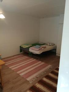 a small room with a bed and a rug at majoitusta in Alavieska