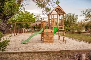 a playground with a slide and a swing set at Agroturismo Can Pere Rei in Son Serra de Marina