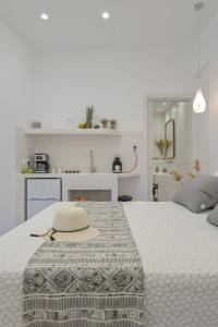 a white bedroom with a bed with a hat on it at Jardin De Castillo , Naxos Town in Naxos Chora