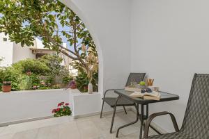 patio ze stołem i krzesłami oraz oknem w obiekcie Jardin De Castillo , Naxos Town w mieście Naksos