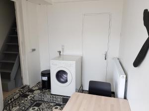 eine Waschküche mit einer Waschmaschine und einem Tisch in der Unterkunft L'Escale Penhoet in Saint-Nazaire