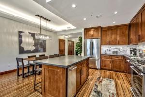 una cucina con armadi in legno, tavolo e frigorifero di Luxury Three Bedroom Residence steps from Heavenly Village condo a South Lake Tahoe