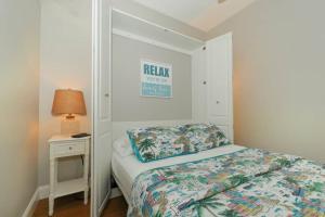 a small bedroom with a bed and a night stand at Siesta Cool: Only Minutes Walk to Siesta Beach! in Siesta Key
