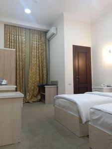 - une chambre d'hôtel avec 2 lits, une table et une piscine dans l'établissement Queens Hotel, à Tachkent
