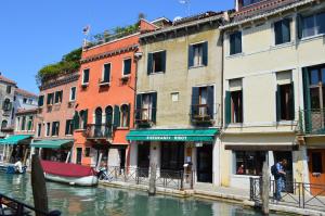 un canal con edificios y un barco en el agua en Hotel Locanda Salieri en Venecia