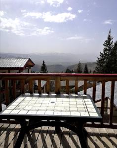 - une table de pique-nique sur une terrasse avec vue sur les montagnes dans l'établissement Font-Romeu près des pistes - Appartement 2 pièces très lumineux avec terrasse et vue panoramique, à Font-Romeu-Odeillo-Via