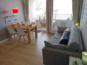 a living room with a couch and a table at fewo1846 Intermar - Kajuete Foerdeblick - familienfreundliches Studioapartment mit Balkon und Meerblick in Glücksburg