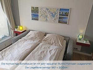 a bed in a room with a map on the wall at fewo1846 Intermar - Kajuete Foerdeblick - familienfreundliches Studioapartment mit Balkon und Meerblick in Glücksburg