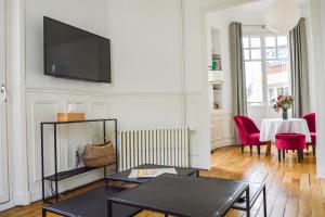 un soggiorno con una TV a schermo piatto su una parete di Les Berceaux de la Cathedrale a Reims