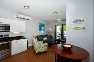 a kitchen and living room with a table and a couch at Siesta Cooler: Only Minutes Walk to Siesta Beach! in Siesta Key