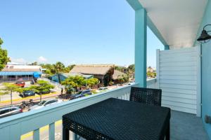 a balcony with a table and a view of a street at Siesta Cooler: Only Minutes Walk to Siesta Beach! in Siesta Key