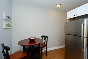 a kitchen with a small table and a refrigerator at Siesta Cooler: Only Minutes Walk to Siesta Beach! in Siesta Key