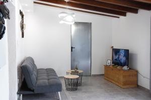 a living room with a couch and a tv at Olea House in Ammouliani