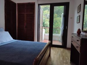 Un dormitorio con una cama y una puerta corrediza de vidrio. en Beach House Emme, en Palaión Tsiflíkion 25 fotos más