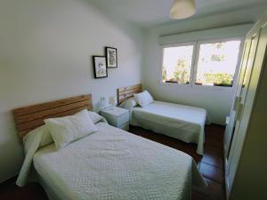 1 dormitorio con 2 camas y ventana en Piso con vistas a la Ría. 6 personas O Grove (Meloxo), en O Grove