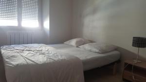 a white bed in a room with a window at Vannes centre logement 3 pièces avec terrasse in Vannes