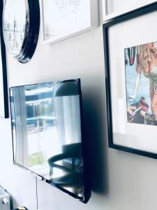 a mirror on a wall with a chair and a clock at Golf Apartament 10 in Wejherowo +17 photos