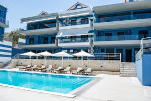 un hotel con piscina frente a un edificio en Anelia's and Lydia's Design Apartments Swimming Pool en Nikiana