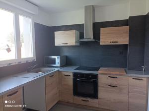 a kitchen with a stove and a microwave at Appartement Fréjus in Fréjus