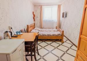 Cette petite chambre comprend un lit et une table. dans l'établissement SAMARIANKA hotel, à Kolomya