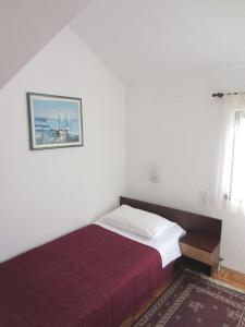 een slaapkamer met een bed en een schilderij aan de muur bij Apartmani Katica in Diklo