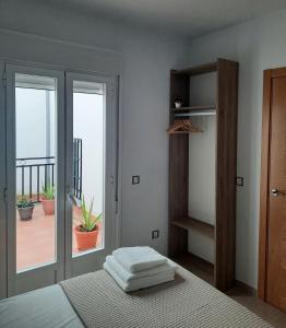a bedroom with a bed with towels on it at Apartamentos Clavero 10 in Plasencia