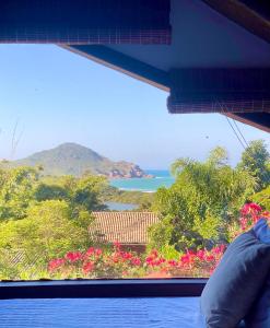 a view of the ocean from a window at Pousada Bungalow in Praia do Rosa