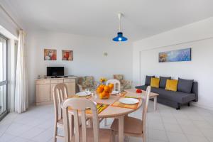 ein Wohnzimmer mit einem Tisch und einem Sofa in der Unterkunft Praia da Rocha, 605 Concorde, Charming Apartment with Sea View, Internet and Parking, By IG in Portimão