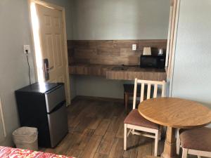 a small room with a table and a small kitchen at Budget inn in Kingsville