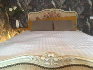 een bed in een slaapkamer met een bloemenmuur bij Auprès du château 2 in Brézé