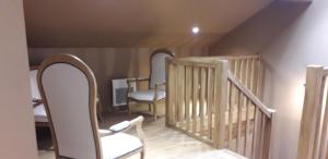 a room with a staircase with chairs and a table at Le Montagnon in Laruns