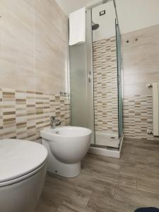 La salle de bains est pourvue de toilettes, d'un lavabo et d'une douche. dans l'établissement Castelvecchio B&B, à Sorano
