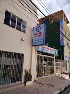 un magasin avec un panneau sur le côté d'un bâtiment dans l'établissement Pousada Catamarã Praia de Pajuçara, à Maceió
