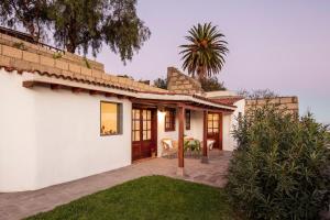 una casa bianca con una palma sullo sfondo di El Sitio de la Casa ad Arico el Nuevo