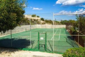 een tennisbaan met een net erop bij 4 persoons bungalow met gemeenschappelijk zwembad in Teulada