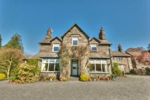 an old stone house with a large driveway at Crow How Country Guest House in Ambleside