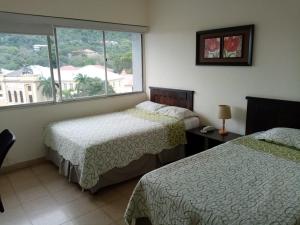巴拿馬城的住宿－多拉酒店，酒店客房设有两张床和窗户。