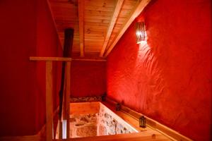 uma casa de banho com uma parede vermelha e uma banheira em Casa dos Alcaides em Sabugueiro