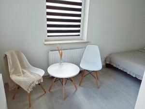 - une chambre avec une table, deux chaises et un lit dans l'établissement Apartament Słoneczne Giżycko, à Giżycko