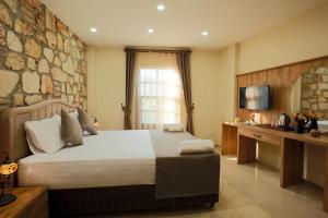 een slaapkamer met een groot bed en een stenen muur bij Castle Inn Boutique Hotel in Antalya