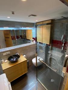 een badkamer met een douche, een toilet en een wastafel bij Apartament 5 in Mielno