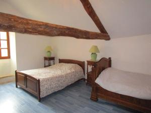 a bedroom with two beds and two lamps at Grand Gîte à la ferme in Les Costes-Gozon