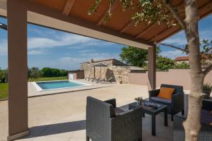 a patio with a table and chairs and a pool at Villa Ester in Pula