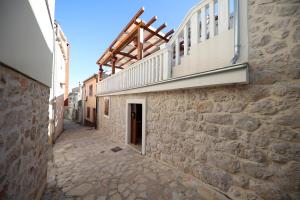 an alley with a building with a balcony on it at Apartmani Dvor Betina in Betina