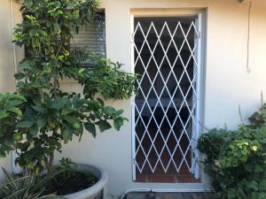 a door with a lattice pattern on the side of a house at Just a Bed parking on street in Stellenbosch